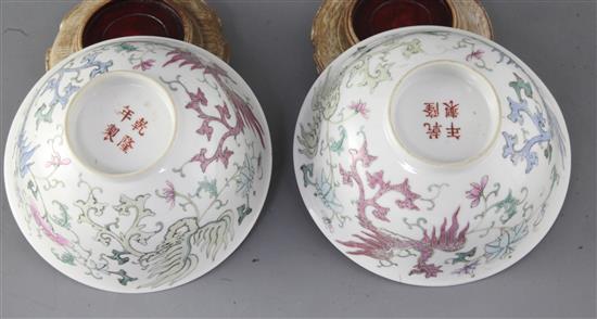 A pair of Chinese famille rose phoenix bowls, Guangxu period, 15.4cm diameter, wood stands